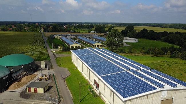 德國一家許農場內的太陽能光電設備與生質能（左邊綠色圓形建築），投入資金主要來自銀行。