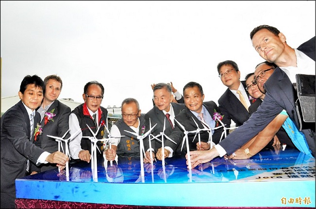台灣首座離岸風場昨在苗栗龍鳳漁港舉行開工典禮，經濟部長沈榮津（左五）等人把「小風車」插上風場示意平台，象徵再生能源永續運轉。（記者彭健禮攝）