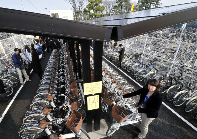 日本提出再生能源調度最佳化的EV應用制度與技術服務研究。圖為太陽能充電的電動腳踏車站，與電動車一樣，可提供再生能源電力調度。法新社